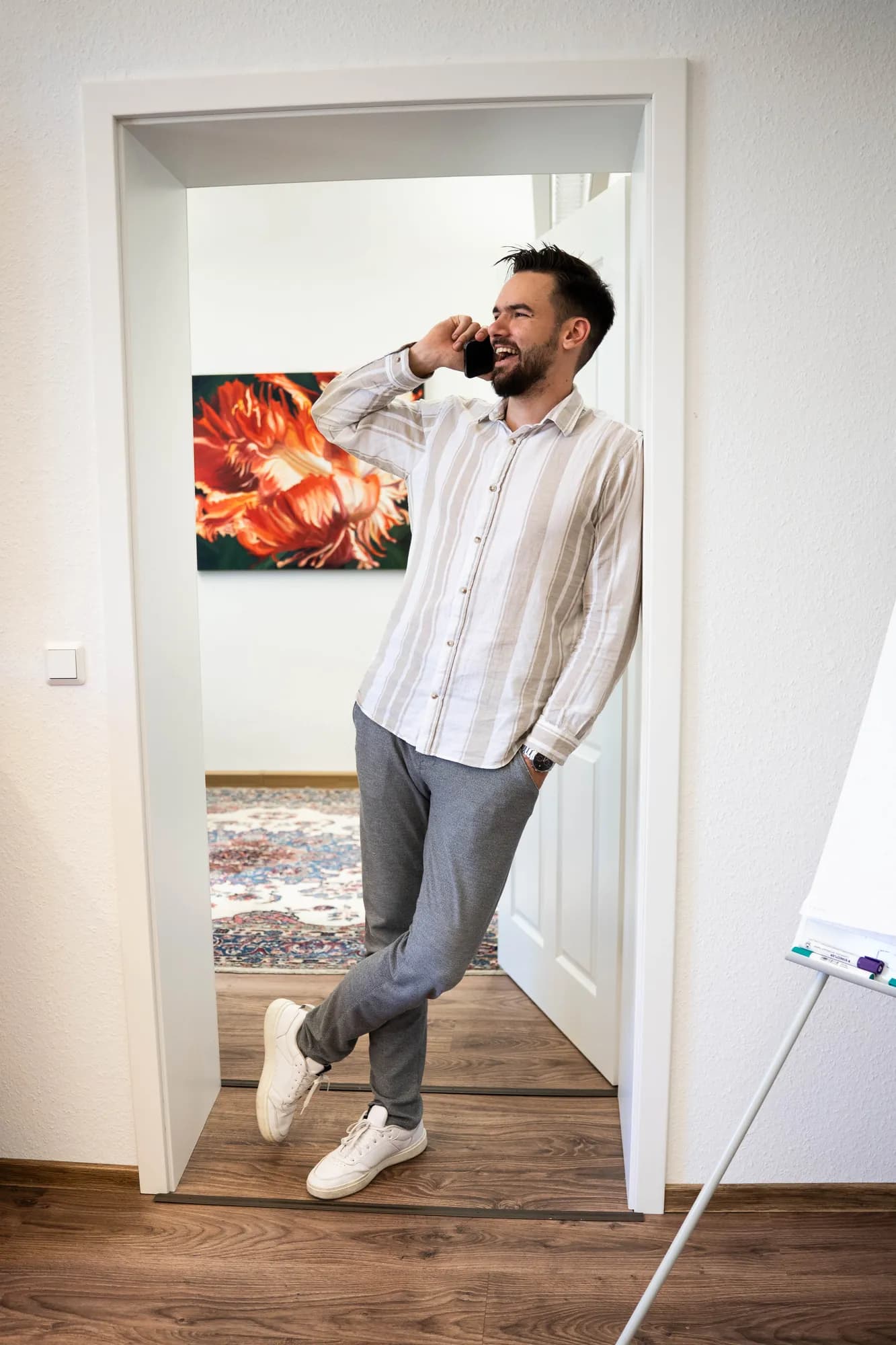 Micha von sorum telefoniert lachend im Büro in Hann. Münden