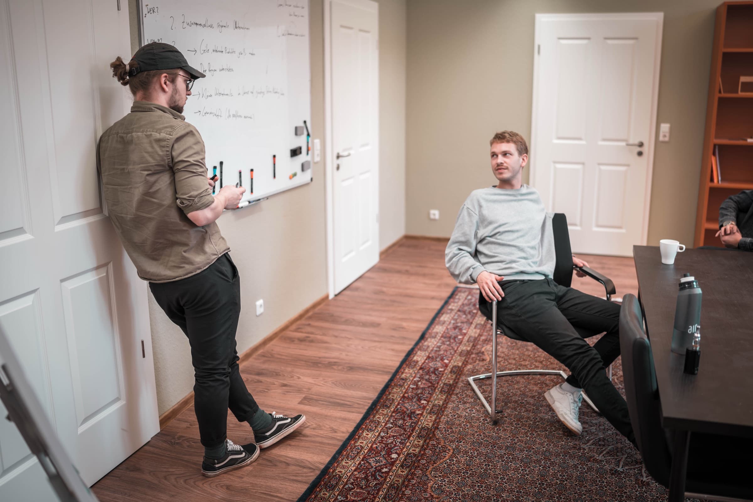 sorum skizziert mit einem Team am Whiteboard, welche Aufgabe zuerst angegangen wird